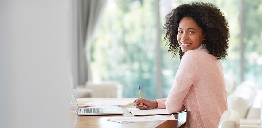 Businesswoman sitting at desk making ambitious plans for the future.