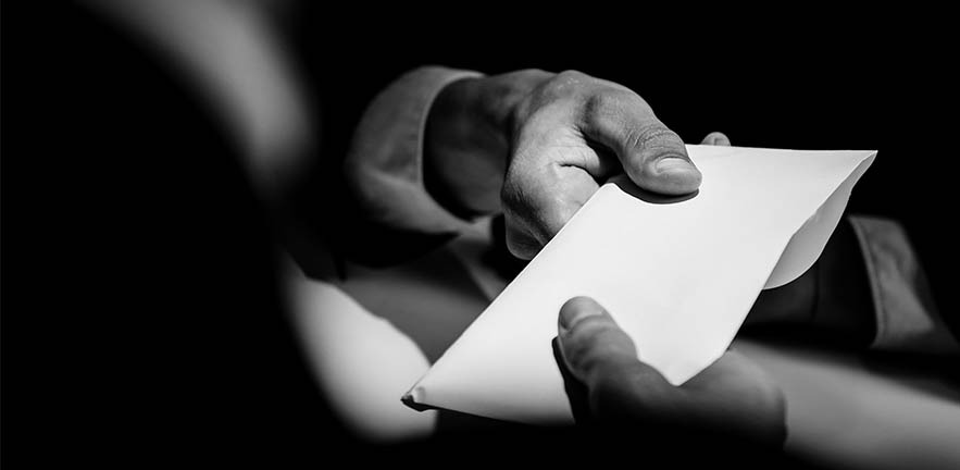 Businessman giving bribe money in the envelope to partner in a corruption scam with black and white tone.