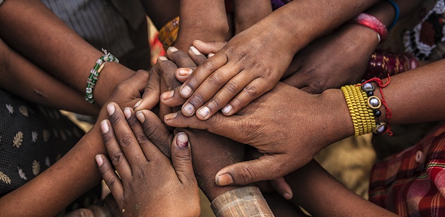 Children's hands in an Indian village, showing community unity.