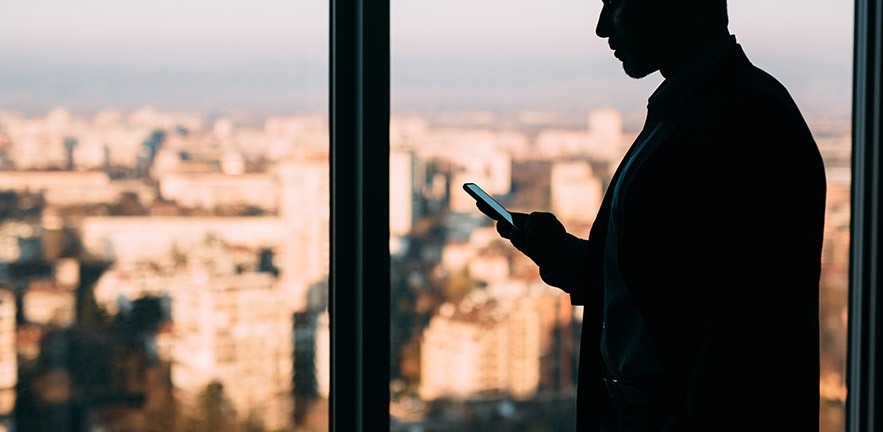 Silhouette of businessman texting.