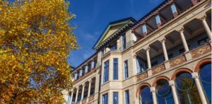 Cambridge Judge Business School with autumnal yellow leaves.