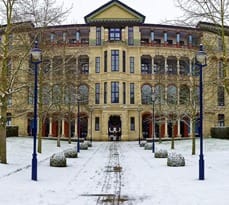 Cambridge Judge Business School surrounded by snow in winter.
