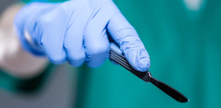 Close-up of hand of doctor holding scalpel.