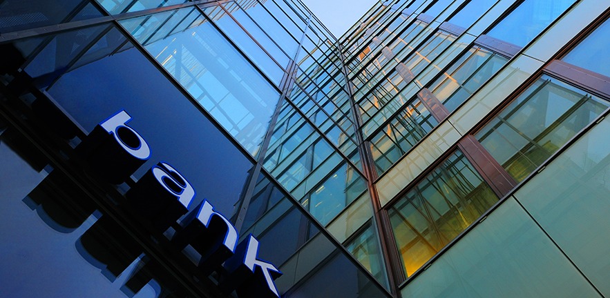 Upward view of a bank building made of glass windows.