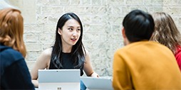 MBA students are sitting around a table in discussion.