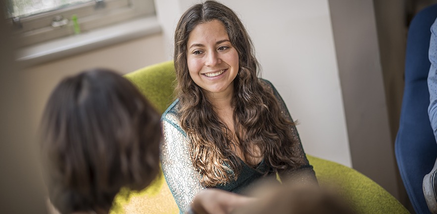 MBA student smiles as she listens to a class mate.