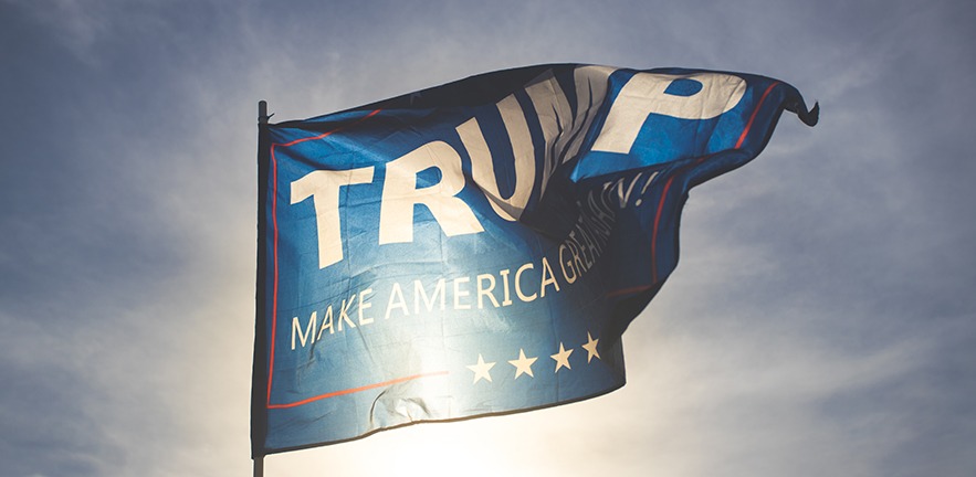 A flag reading "Trump: make America great again!" flaps in the wind just before sunset in Las Vegas, Nevada.