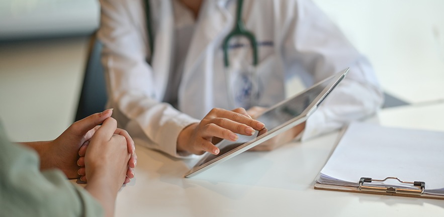 Shot of a doctor showing a patient some information on a digital tablet.