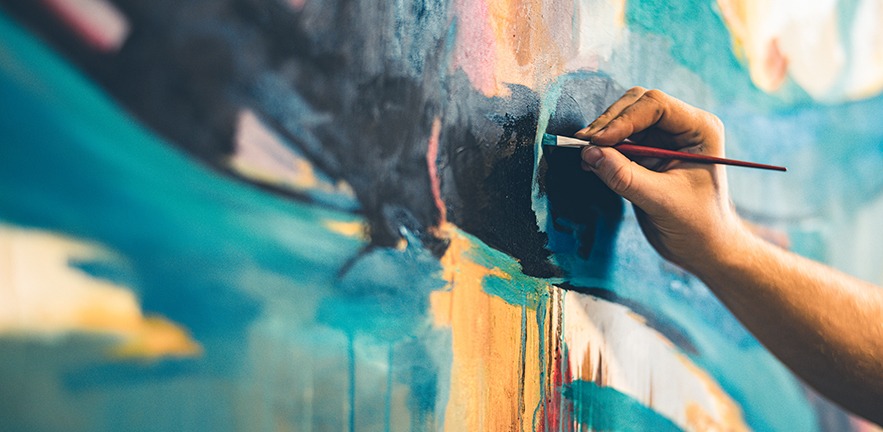 Hands of young painter working on his art inside his studio.