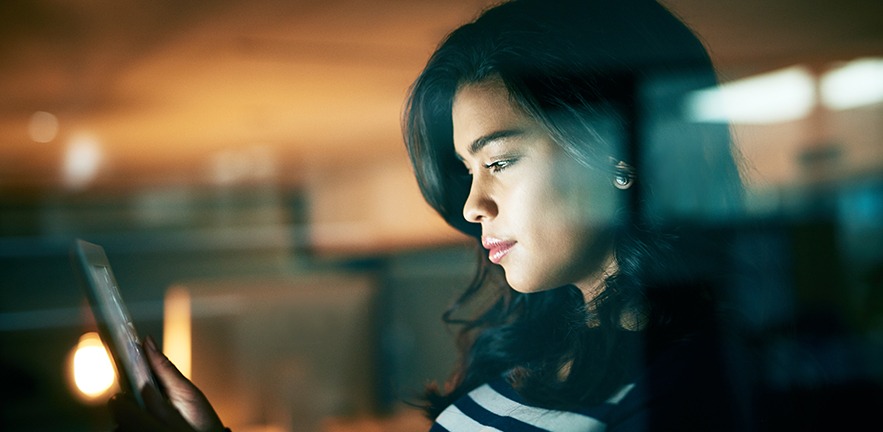 Shot of a young businesswoman working late on a digital tablet