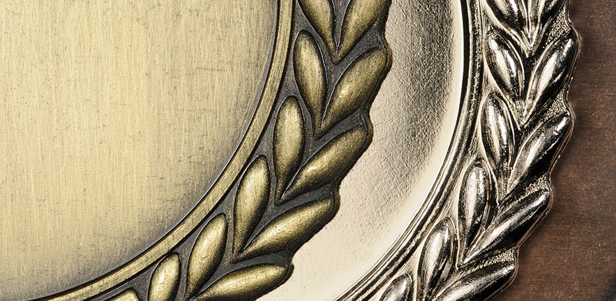 Metal medals with leafy edge decoration.
