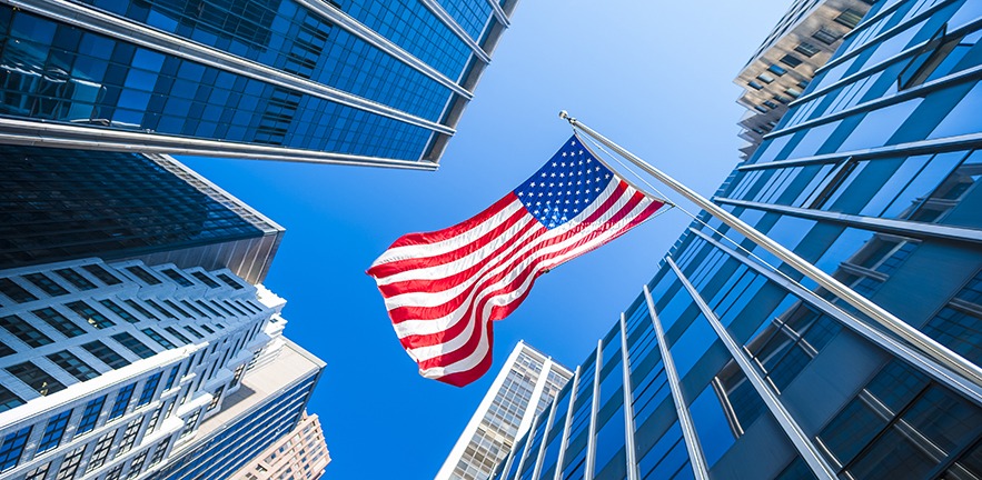 USA flag and contemporary glass architecture of Financial District, New York City, USA.