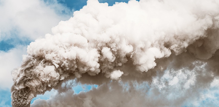 Air pollution: Thick smoke billowing into the sky from a factory chimney.