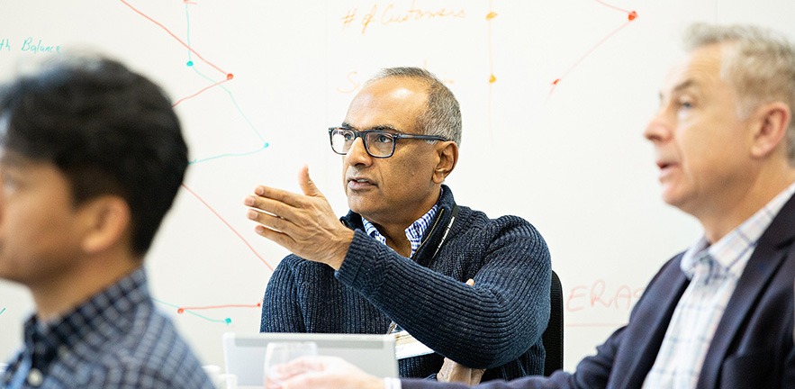 Image of a man in a classroom, taking part in a group discussion.