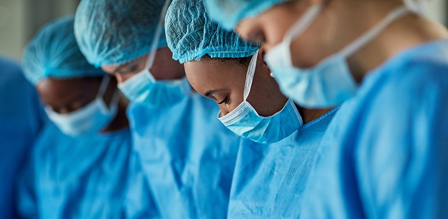 Cropped shot of a group of surgeons performing a medical procedure in an operating room.