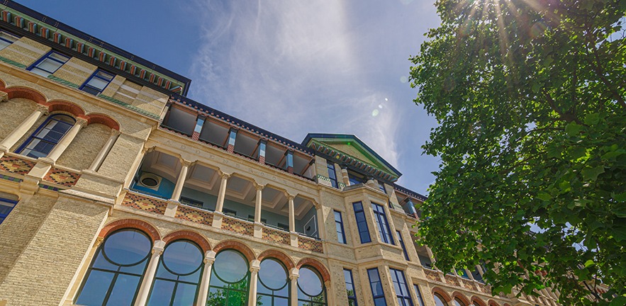 Exterior of Cambridge Judge Business School in bright sunshine.