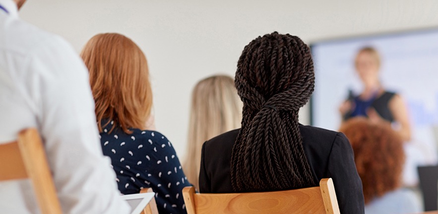 Rearview shot of an audience of businesspeople attending a conference.