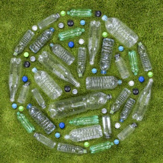 Plastic drinks bottles arranged in a circle on grass.