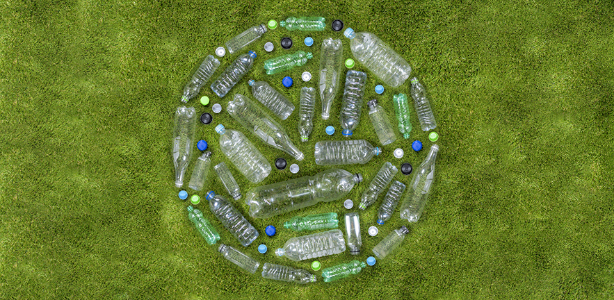 Plastic drinks bottles arranged in a circle on grass.