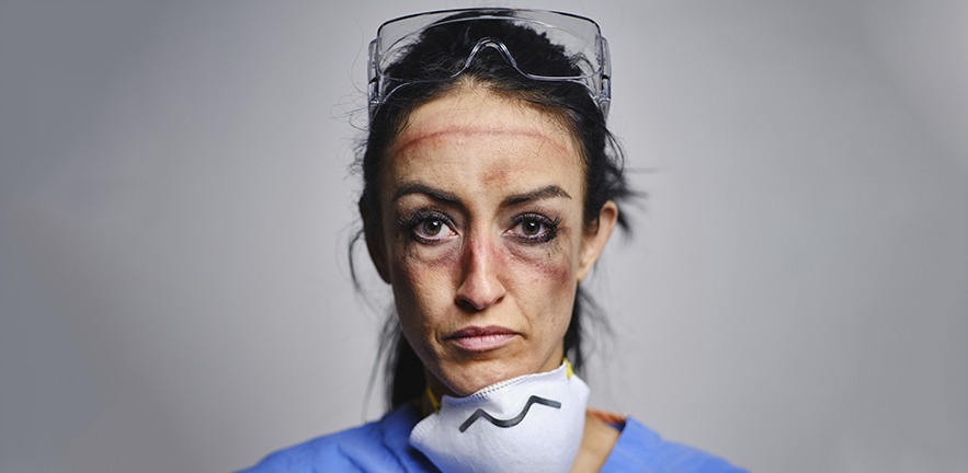 A healthcare worker showing the signs of fatigue from working long hours combatting communicable disease in a hospital.