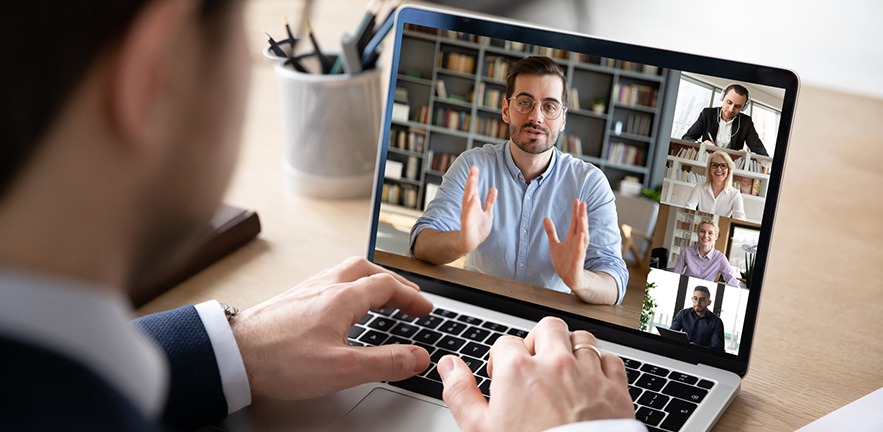 Team holding business meeting via online video conferencing.