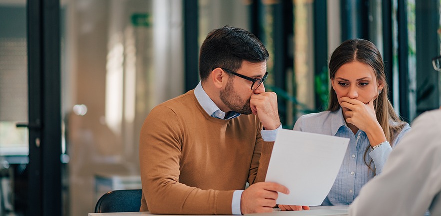 Portrait of a couple of investors looking concerned.