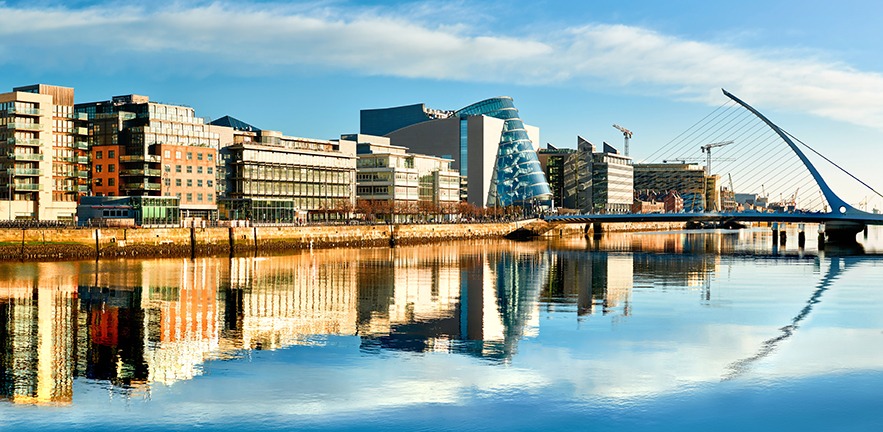 Modern buildings and offices on Liffey river in Dublin on a bright sunny day.