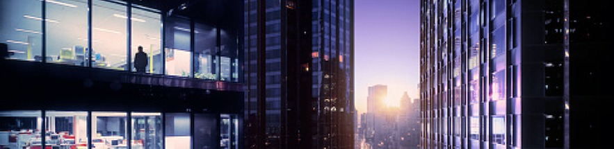 City view through skyscrapers at sunset, the city is still bright with light.