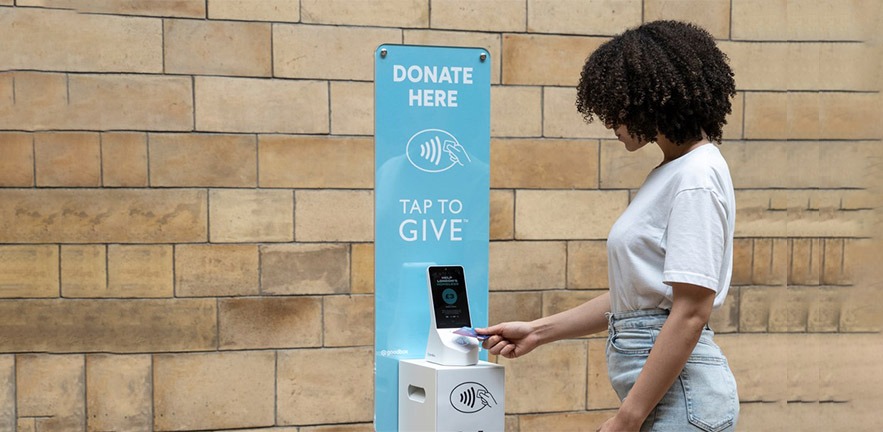 Woman using contactless device to donate money.