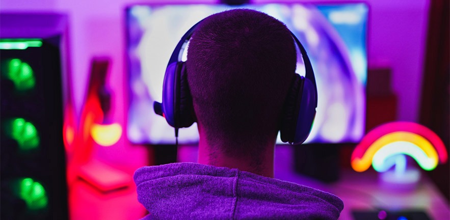 Young man wearing headset and play computer video games online.