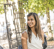 Female MBA student smiling outside in sunshine.