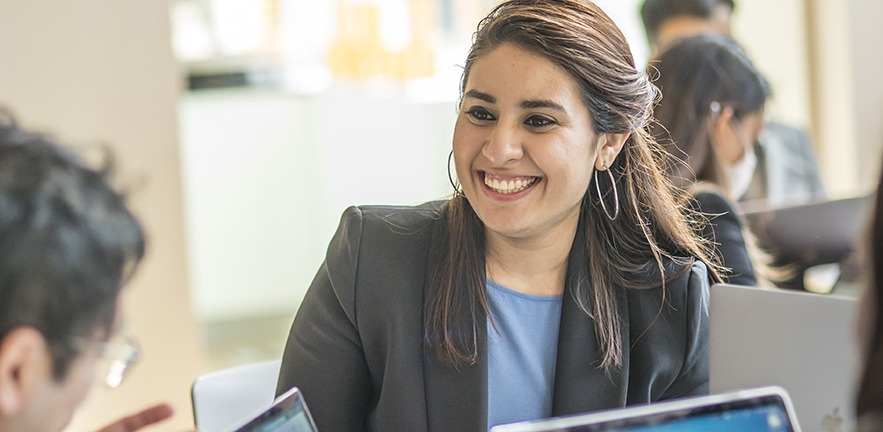 Smiling female MBA student working with others.