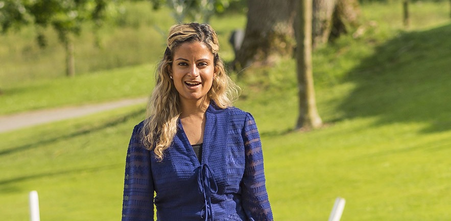 Smiling female MBA student outside in sunny weather.