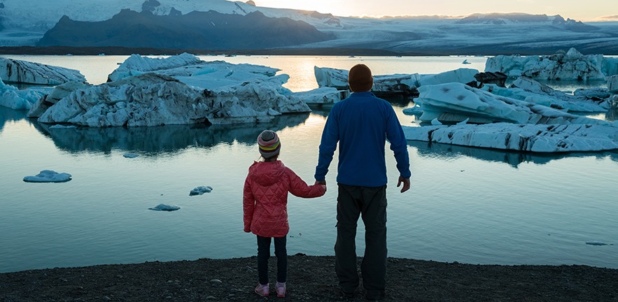 A family observes the icebergs melting at the Jokulsarlon Lagoon in Iceland.