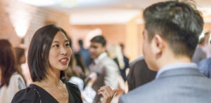 Male and female MBA students talking at an event.