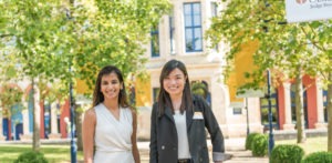 Two MBA students standing outside the Business School building casually.