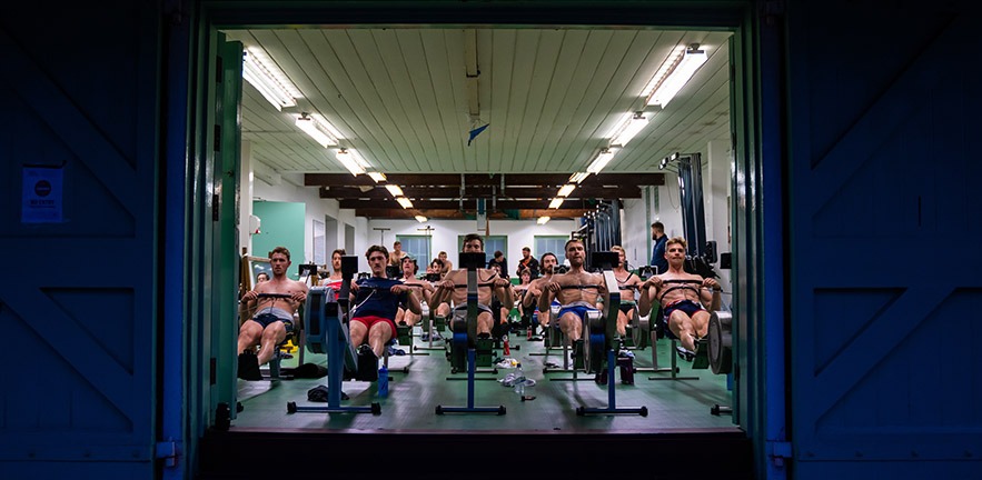 Men on rowing machines.