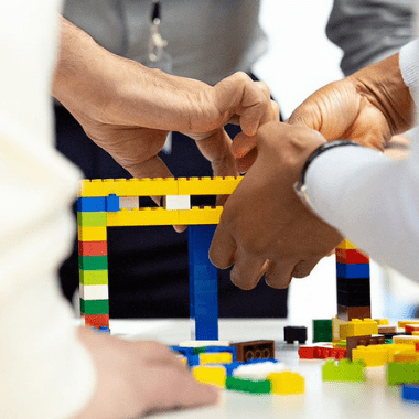 Team building a mini structure in a creative session.