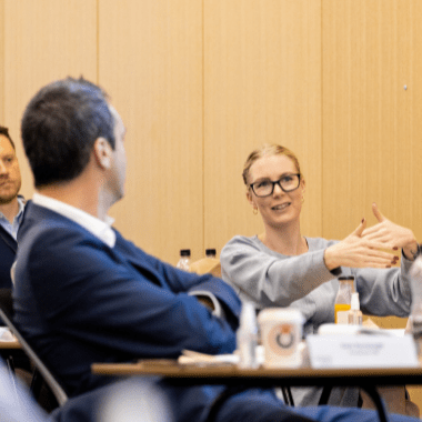 Woman in classroom explaining a business challenge to lecturer.