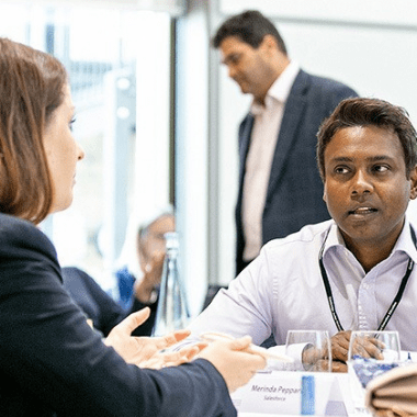 Two delegates discuss a project at a workshop.