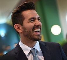 Laughing male MBA student in a suit.