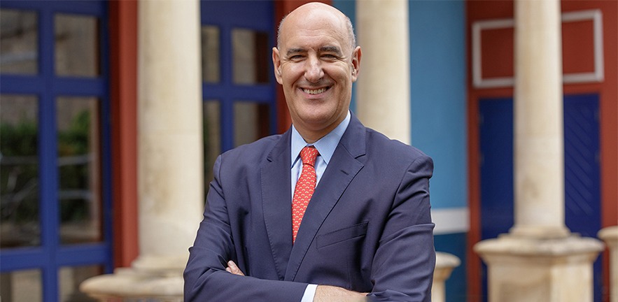 Mauro Guillén standing in front of Cambridge Judge Business School.