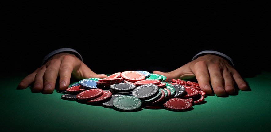 Hands next to a pile of poker chips.