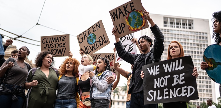 Protestors holding signs during on a demonstration for environmentalism.