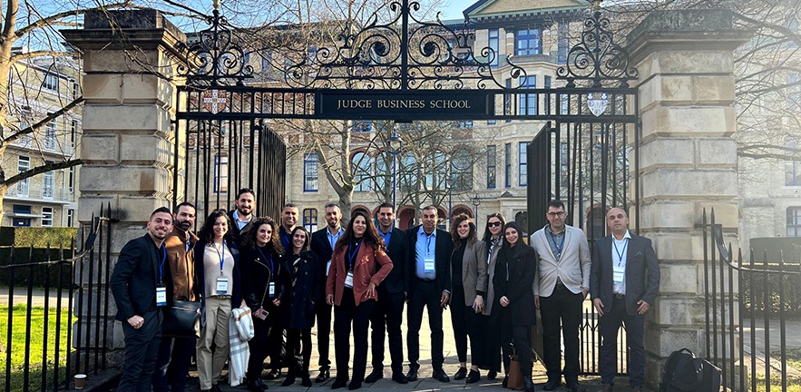 Participants on the Al-Mada programme outside the gates of Cambridge Judge Business School.