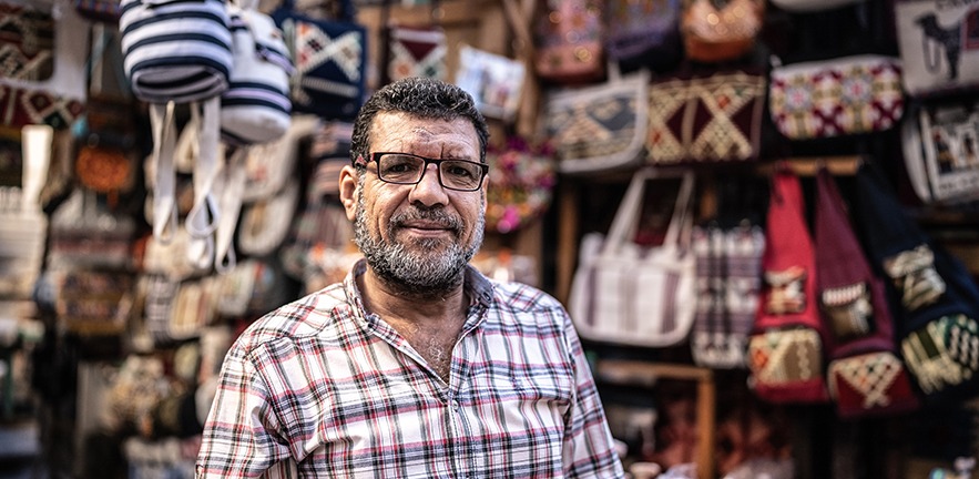 Portrait of a mature man in front of his store on a bazaar market.