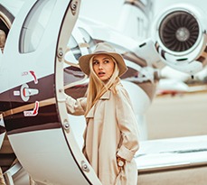 Young rich blonde female getting on board her private airplane.