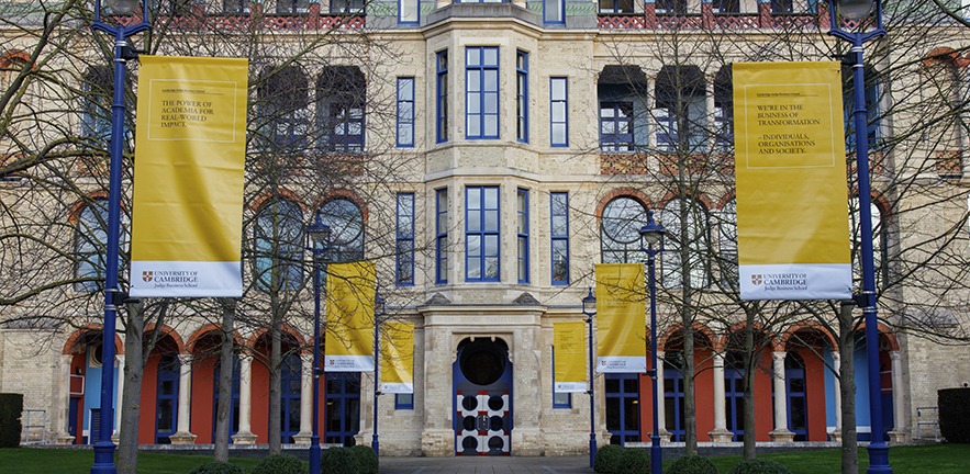 Yellow banners outside Cambridge Judge Business School.