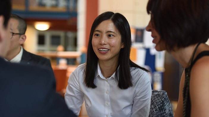 Executive MBA student chatting with peers.