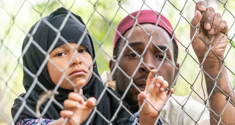 A Muslim girl and her father being held in a refugee camp.
